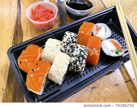 Set of rolls, ginger, soy sauce, sticks on wooden table. Set of rolls, ginger, soy sauce, sticks on wooden table. 74380250