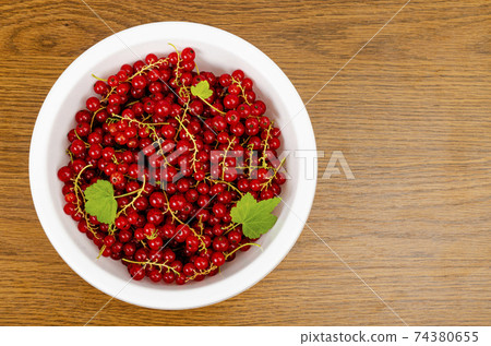 Ripe red currants in white bowl. Photo Ripe red currants in white bowl. Photo 74380655
