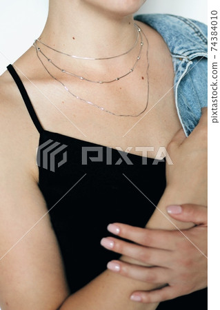 Tender jewerly on female neck, close up shot Tender jewerly on female neck, close up shot 74384010