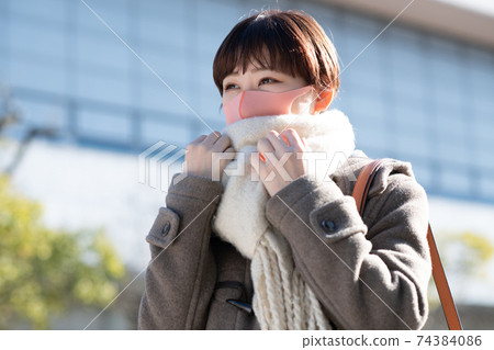 Winter woman wearing a coat, scarf and mask 74384086
