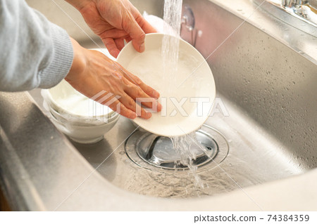 Hands of a man washing dishes 74384359