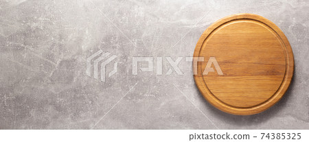 Pizza or bread cutting board for homemade baking on table. Food recipe concept at stone background Pizza or bread cutting board for homemade baking on table. Food recipe concept at stone background 74385325