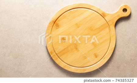 Pizza or bread cutting board for homemade baking on table. Food recipe concept Pizza or bread cutting board for homemade baking on table. Food recipe concept 74385327
