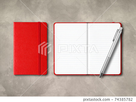 Red closed and open lined notebooks with a pen on concrete background 74385782