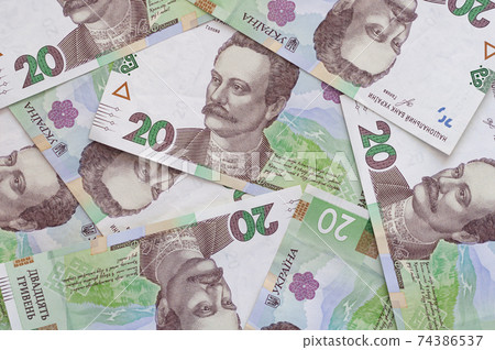 Paper money, Ukrainian hryvnia in denomination 20 hryvnia, new money, background with scattered banknotes. Paper money, Ukrainian hryvnia in denomination 20 hryvnia, new money, background with scattered banknotes. 74386537