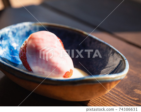 Strawberries with condensed milk. Fresh and bright red fruit. 74386631