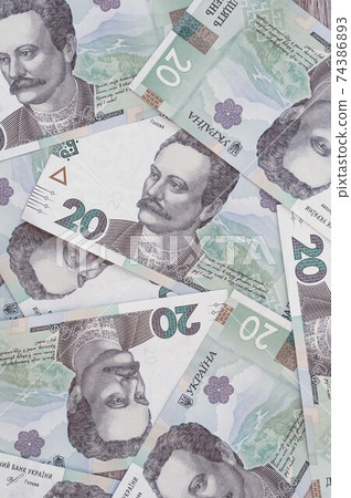 Paper money, Ukrainian hryvnia in denomination 20 hryvnia, new money, background with scattered banknotes Paper money, Ukrainian hryvnia in denomination 20 hryvnia, new money, background with scattered banknotes 74386893