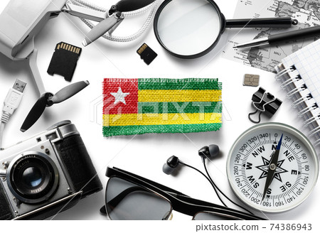 Flag of Togo and travel accessories on a white background. 74386943