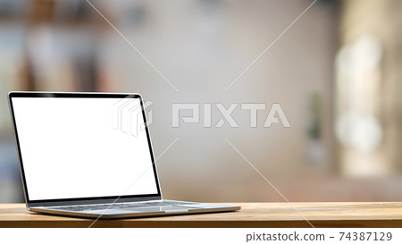 Computer laptop with white blank screen putting on the modern working table with blurred comfortable office as background. Void screen for advertise concept. Computer laptop with white blank screen putting on the modern working table with blurred comfortable office as background. Void screen for advertise concept. 74387129