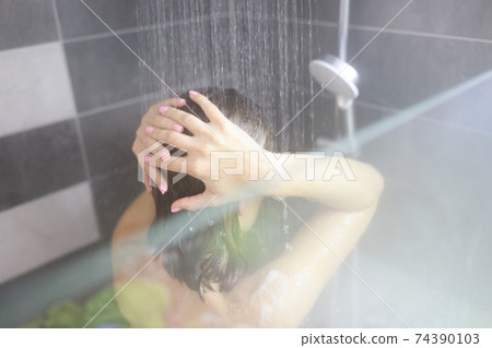Woman takes hot shower in bathroom closeup Woman takes hot shower in bathroom closeup 74390103