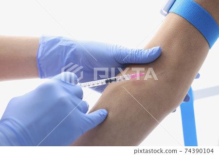 Gloved hands of doctor inject a patient into vein Gloved hands of doctor inject a patient into vein 74390104