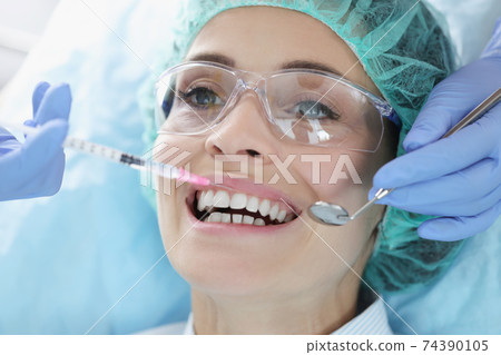 Doctor gives woman an anesthetic injection closeup Doctor gives woman an anesthetic injection closeup 74390105