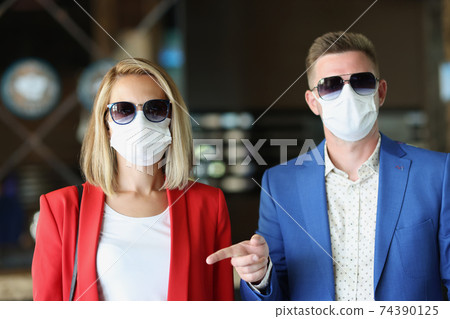Portrait of man and woman wearing medical protective masks Portrait of man and woman wearing medical protective masks 74390125