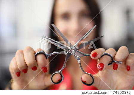 Hairdresser holds working scissors with comb in his hands 74390572