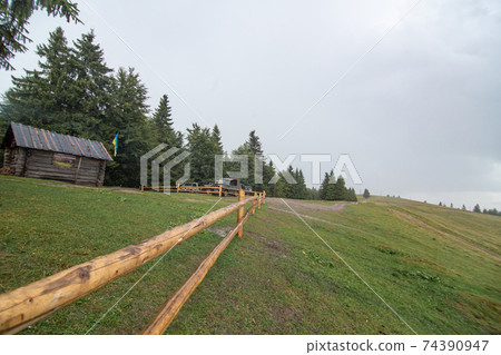 Wooden log huts of farm in mountain forest Wooden log huts of farm in mountain forest 74390947