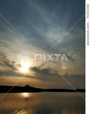Natural landscape. Sunset over water, reflection of the sun and clouds in the water Natural landscape. Sunset over water, reflection of the sun and clouds in the water 74391000