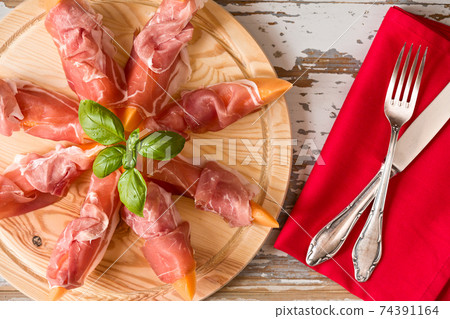 Italian prosciutto and melon with basil 74391164
