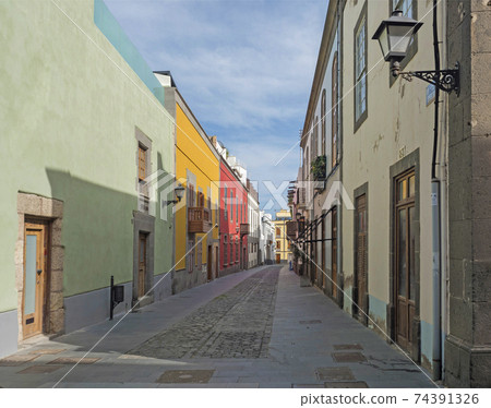 Pedestrian street of beautiful historic old town Vegueta. Houses with colorful facades and traditional wooden balcony. Las Palmas de Gran Canaria at sunny day. Canary Islands, Spain Pedestrian street of beautiful historic old town Vegueta. Houses with colorful facades and traditional wooden balcony. Las Palmas de Gran Canaria at sunny day. Canary Islands, Spain 74391326
