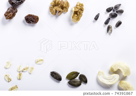 Seeds of sunflower, nuts, fruits and dried fruits on white background with copy space. Seeds of sunflower, nuts, fruits and dried fruits on white background with copy space. 74391867