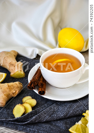 Ginger hot immunity boosting Vitamin natural drink With citrus lemon cinnamon anise in a rustic style on wooden background. Chamomile tea. Ginger hot immunity boosting Vitamin natural drink With citrus lemon cinnamon anise in a rustic style on wooden background. Chamomile tea. 74392205