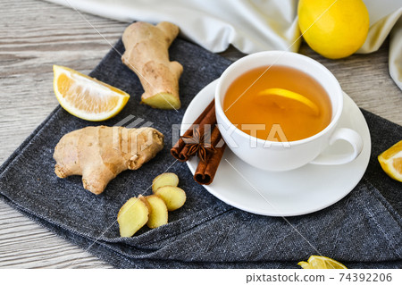 Ginger hot immunity boosting Vitamin natural drink With citrus lemon cinnamon anise in a rustic style on wooden background. Chamomile tea. Ginger hot immunity boosting Vitamin natural drink With citrus lemon cinnamon anise in a rustic style on wooden background. Chamomile tea. 74392206