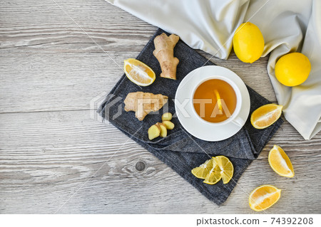 Ginger hot immunity boosting Vitamin natural drink With citrus lemon cinnamon anise in a rustic style on wooden background. Chamomile tea. 74392208