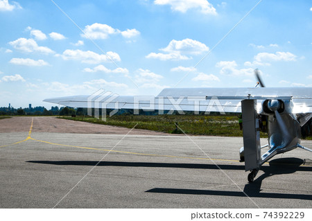 A small plane stands in the parking lot of an old airfield. Wings. Airport. Airfield. Flights by plane. A small plane stands in the parking lot of an old airfield. Wings. Airport. Airfield. Flights by plane. 74392229