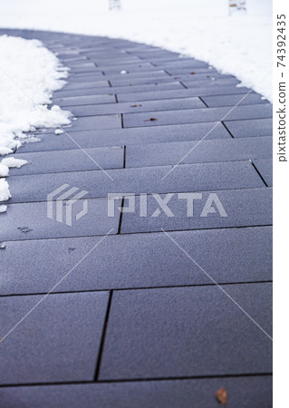 Stone path in the park in the snow close-up. Stone path in the park in the snow close-up. 74392435