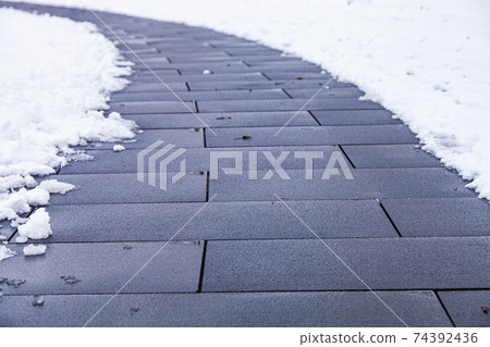 Stone path in the park in the snow close-up. 74392436