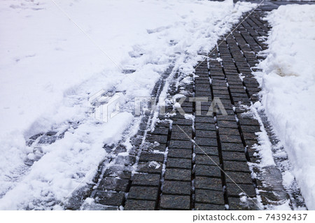 Stone path in the park in the snow close-up. Stone path in the park in the snow close-up. 74392437