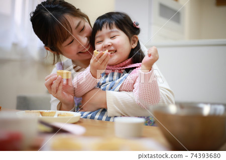Parents and children eating the sweets they made 74393680