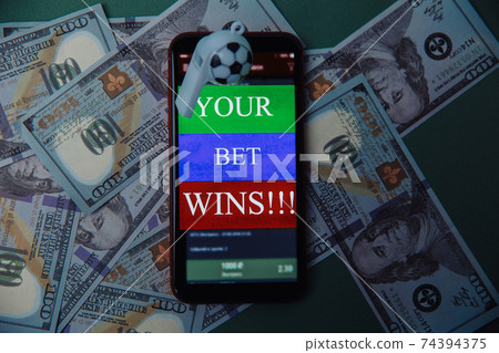 Whistle and smartphone with bet application on dollar bills and green background. Gambling and bet concept. Top view 74394375