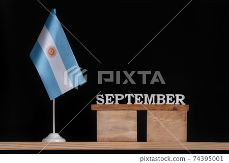 Wooden calendar of September with Argentine flag on black background. Holidays of Argentina in September. Wooden calendar of September with Argentine flag on black background. Holidays of Argentina in September. 74395001