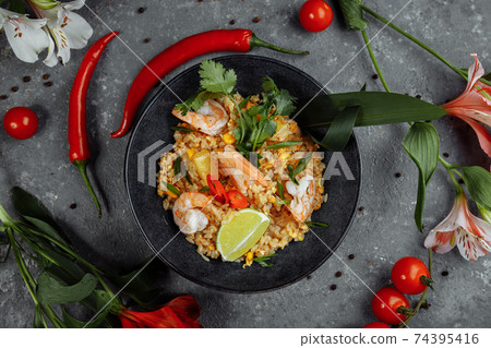 Thai rice with shrimp in a black plate on a dark background. copyright place Thai rice with shrimp in a black plate on a dark background. copyright place 74395416