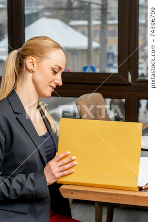 Young businesswoman looking at folder Young businesswoman looking at folder 74396709