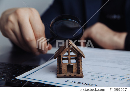 Man's hand, magnifier and house. Concept of rent, search, purchase real estate Man's hand, magnifier and house. Concept of rent, search, purchase real estate 74399927