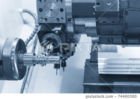 The turn-mill machine cutting the metal shaft part. The turn-mill machine cutting the metal shaft part. 74400300