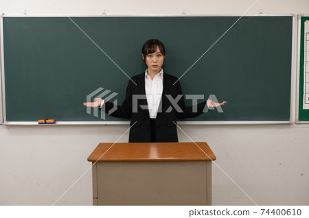 Teacher comparing in front of the blackboard 74400610