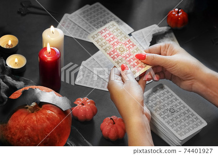 Tarot reader with tarot cards. Halloween concept, fortune telling. Tarot reader with tarot cards. Halloween concept, fortune telling. 74401927