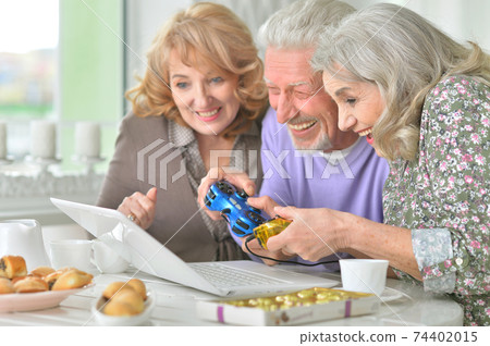 Portrait of happy senior people playing computer game Portrait of happy senior people playing computer game 74402015