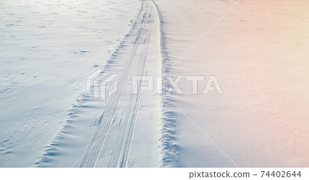 Car traces on snow field 74402644