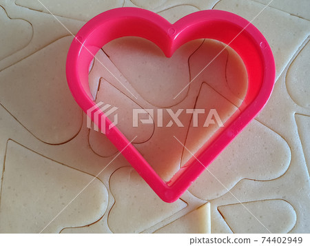 Heart shaped cookie cutter with cut hearts. Pastry background. Valentine's Day, greeting card, pastry, Copy space, top view, love concept, Engagement, love, marriage 74402949