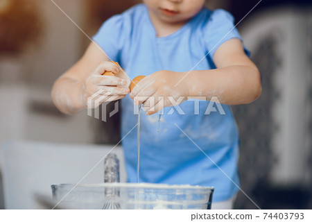 Little girl cook the dough for cookies 74403793