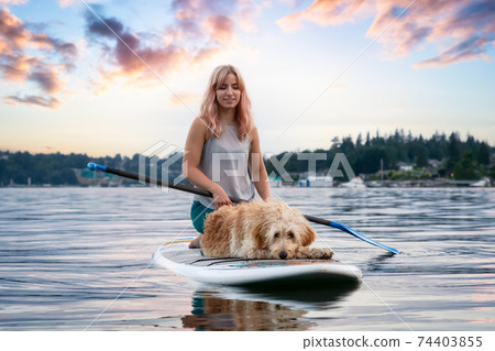 Girl with a dog on a paddle board 74403855
