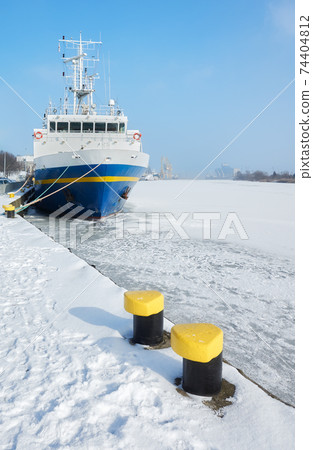 Mooring bollards on a pier by frozen Odra River in Szczecin, Poland. 74404812