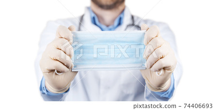 Hands in medical gloves hold medical protective mask. 74406693