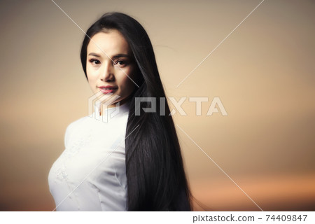 Portrait of Beautiful Asian girls with Ao Dai vietnam traditional dress on Sunset landscapes 74409847