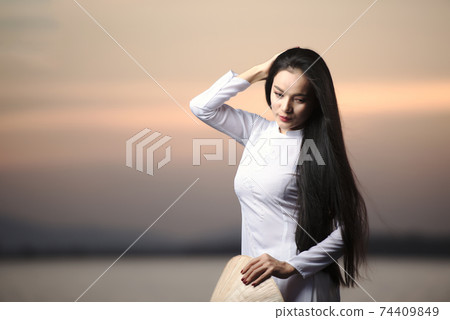 Portrait of Beautiful Asian girls with Ao Dai vietnam traditional dress on Sunset landscapes 74409849