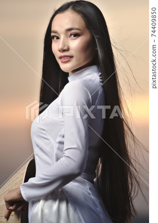 Portrait of Beautiful Asian girls with Ao Dai vietnam traditional dress on Sunset landscapes Portrait of Beautiful Asian girls with Ao Dai vietnam traditional dress on Sunset landscapes 74409850