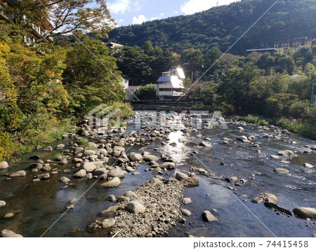The riverbank of Hakone in early winter. The sun shines on the surface of the water, creating a melancholy and bright landscape. It is a walk course. The riverbank of Hakone in early winter. The sun shines on the surface of the water, creating a melancholy and bright landscape. It is a walk course. 74415458